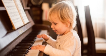 Bimbo suona il pianoforte durante la prima infanzia