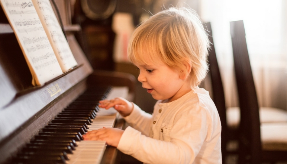 Bimbo suona il pianoforte durante la prima infanzia