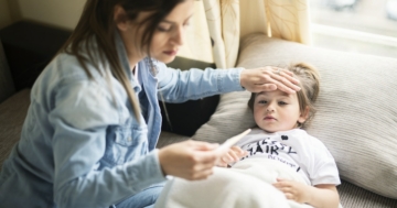 Mamma misura la febbre al suo bambino