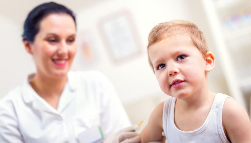 Bambino piccolo che viene vaccinato da un medico