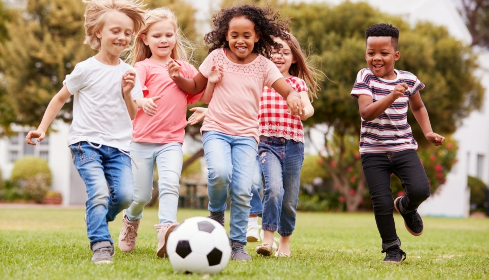 Bambine e bambini giocano a calcio