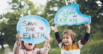 Bambini con cartelli che manifestano contro il cambiamento climatico