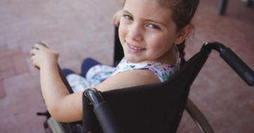 Primo piano di bambina con disabilità su sedia a rotelle