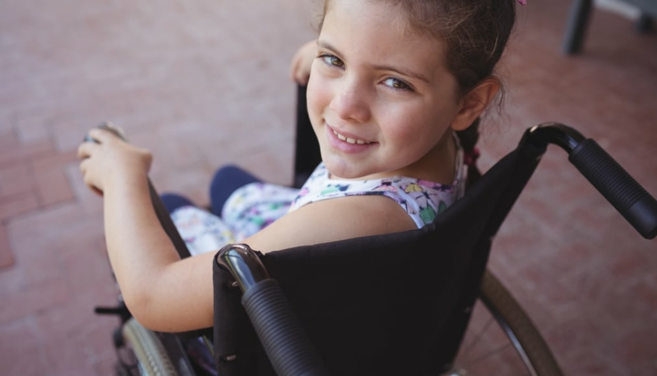 Primo piano di bambina con disabilità su sedia a rotelle
