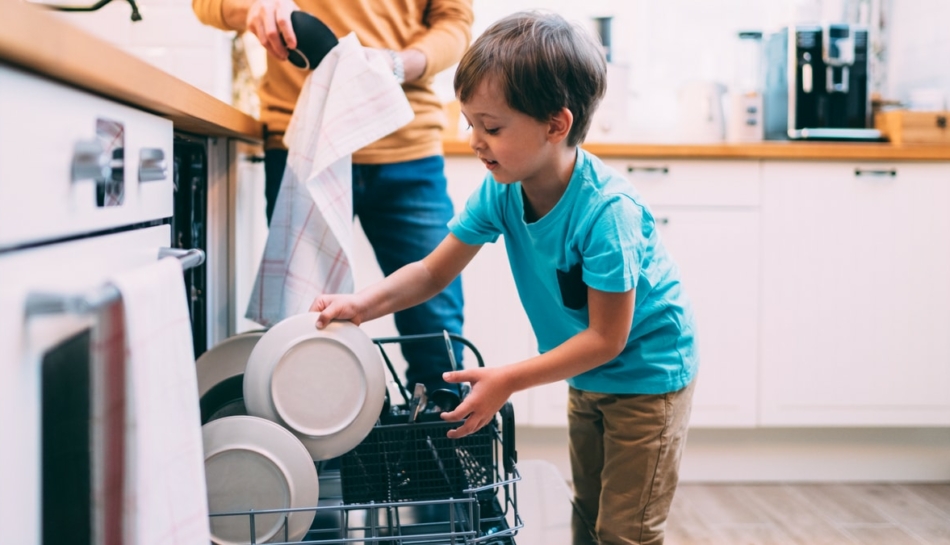 Bambino obbediente aiuta a caricare la lavastoviglie