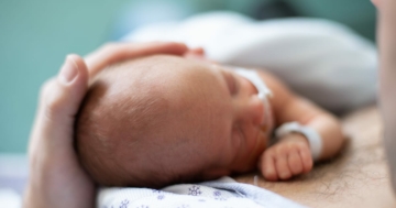 vista dall'alto della testa di un neonato prematuro con il padre