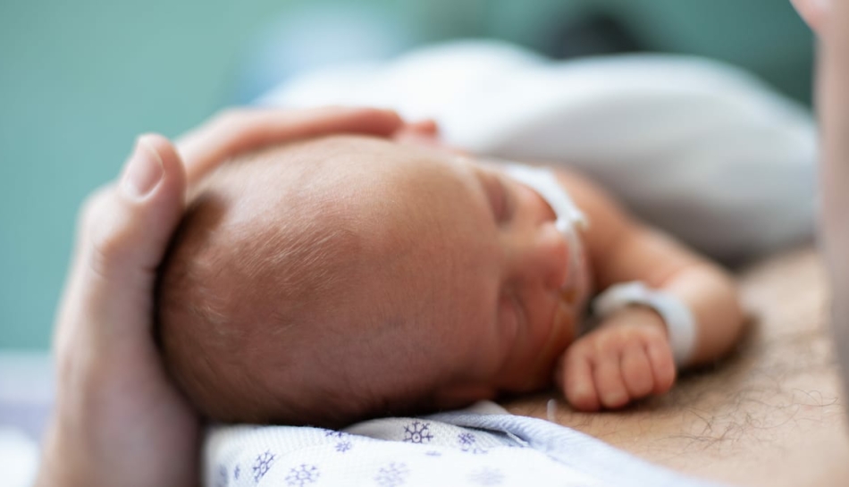 vista dall'alto della testa di un neonato prematuro con il padre