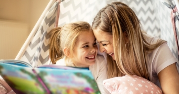 a mother reads a picture book with her daughter