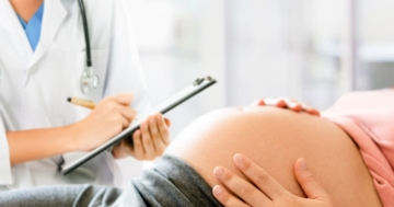 una donna incinta sdraiata parla con il suo medico
