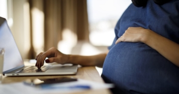 Donna in gravidanza che usa un laptop