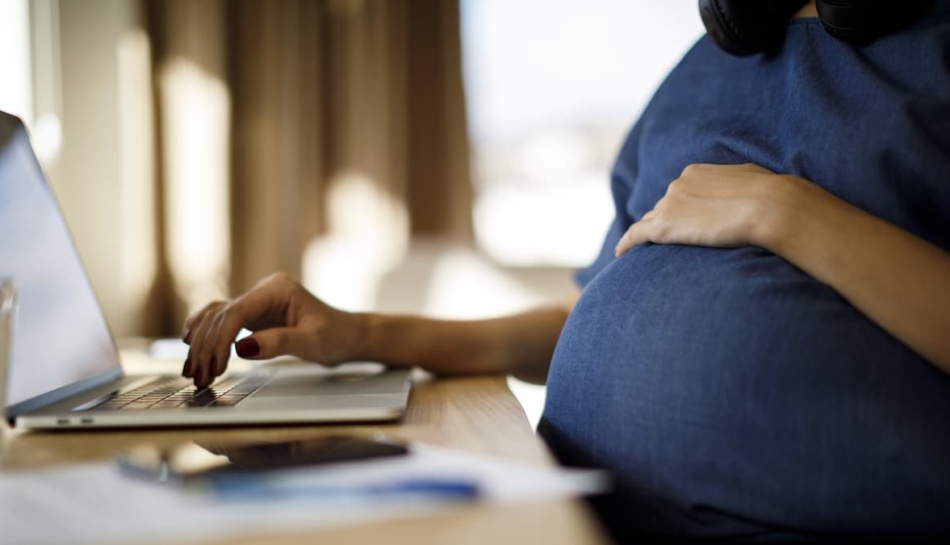 Donna in gravidanza che usa un laptop
