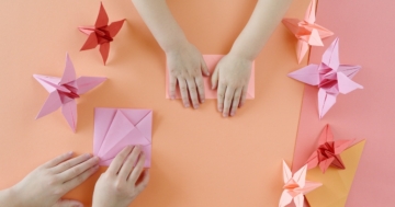 Children's hands making origami