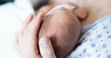 Testa di un neonato pretermine accarezzata dal papà