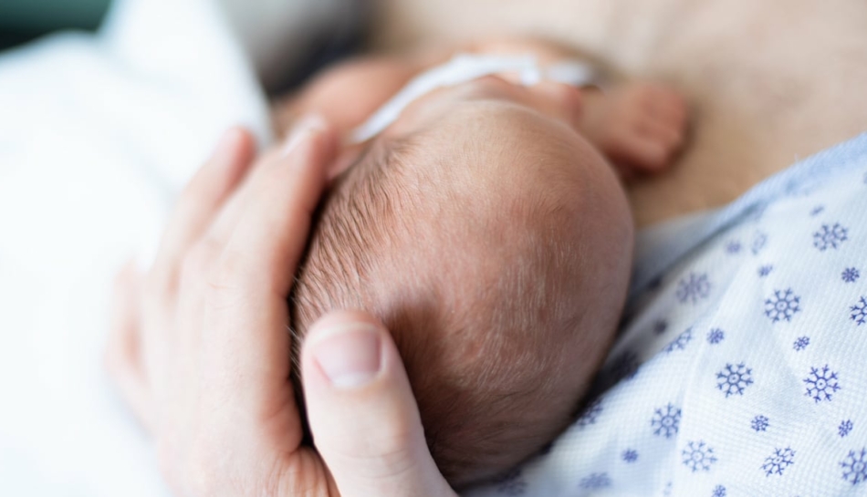 Testa di un neonato pretermine accarezzata dal papà