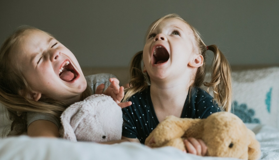 Due bambine che urlano sdraiate sul letto