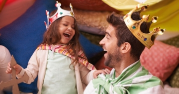 Una bambina gioca con il suo papà e sono entrambi travesti da re protagonisti dei classici per l'infanzia