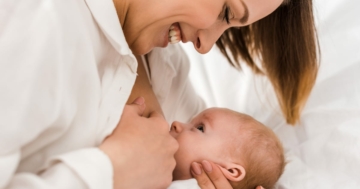 Mamma sorride durante l'allattamento