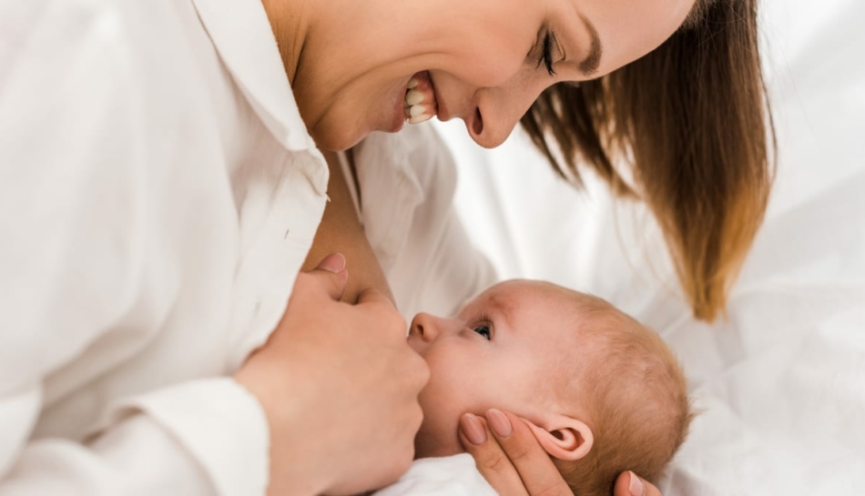 Mamma sorride durante l'allattamento