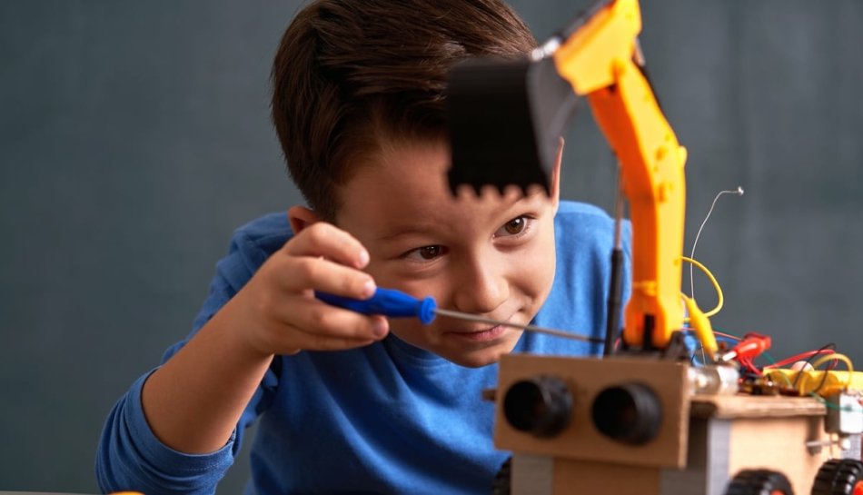 Bambino di circa 6 anni che costruisce un piccolo robot