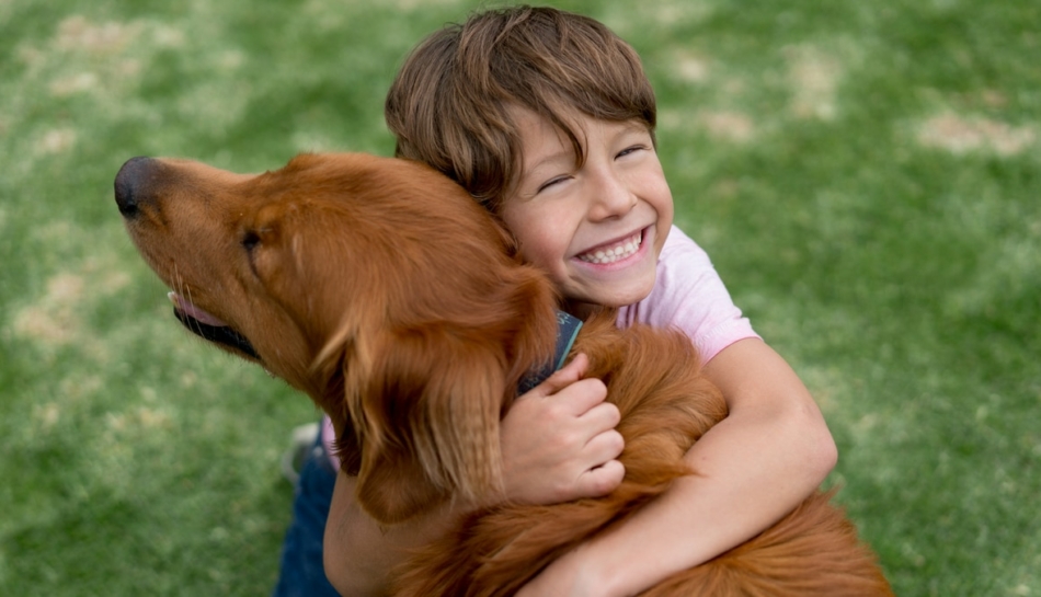 Un bambino abbraccia felice il suo cane