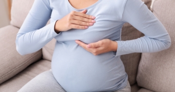 Donna in gravidanza si tasta il seno