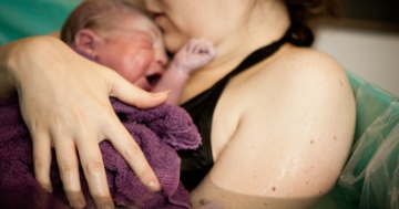 Donna con il suo bambino subito dopo il parto in acqua