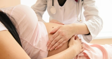 Primo piano di un dottore che verifica la posizione del feto in una gravidanza a termine, per verificare se si tratta di un parto podalico