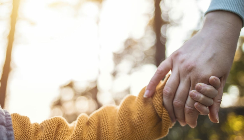 bambino adottato per mano con la mamma