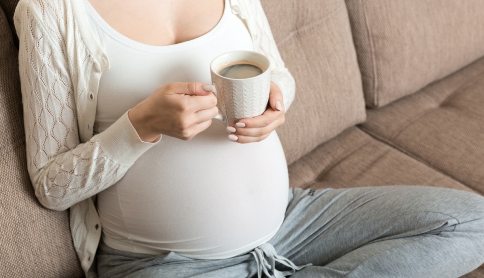 donna beve tazza di caffè in gravidanza
