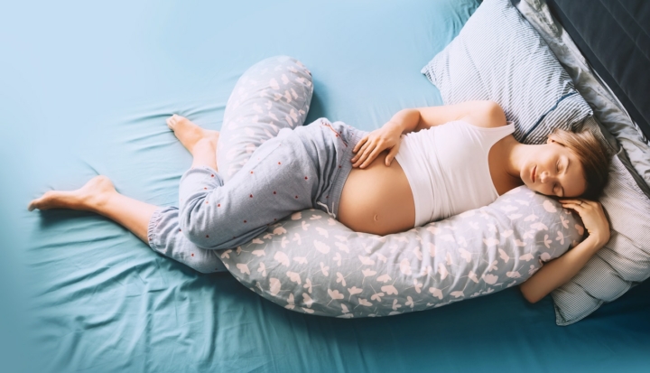 donna in gravidanza dorme con cuscino