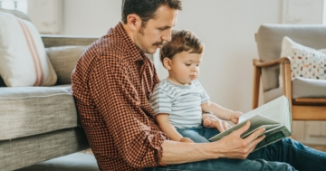 padre insegna a leggere al suo bambino