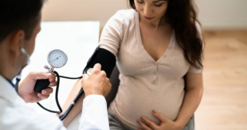 medico misura la pressione a donna in gravidanza