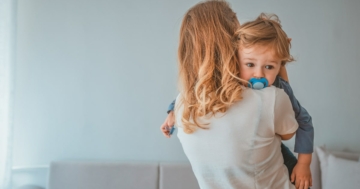 mamma consola piccolo a cui cerca di togliere il ciuccio