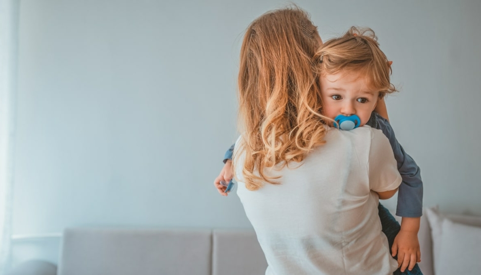 mamma consola piccolo a cui cerca di togliere il ciuccio