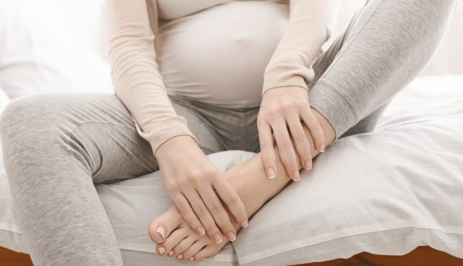 donna in gravidanza massaggia piedi gonfi