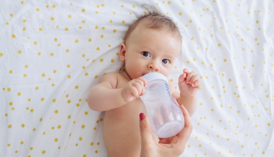 neonato beve camomilla da biberon