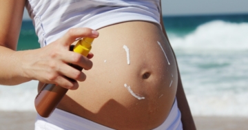 donna in gravidanza mette crema solare sulla pancia