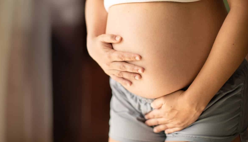 donna con cistite in gravidanza si tocca la pancia