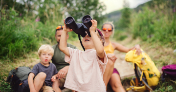 Bambina usa il binocolo in montagna