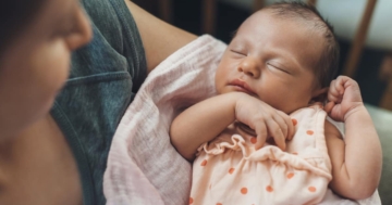 neonato dorme nelle braccia della mamma