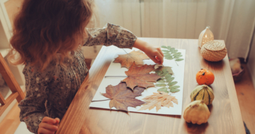bambina gioca in casa con le foglie