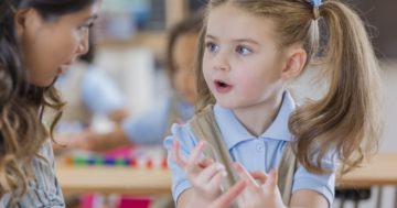 Little girl learns multiplication tables with teacher