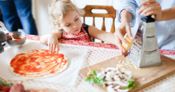 bambina prepara pizza con funghi con mamma