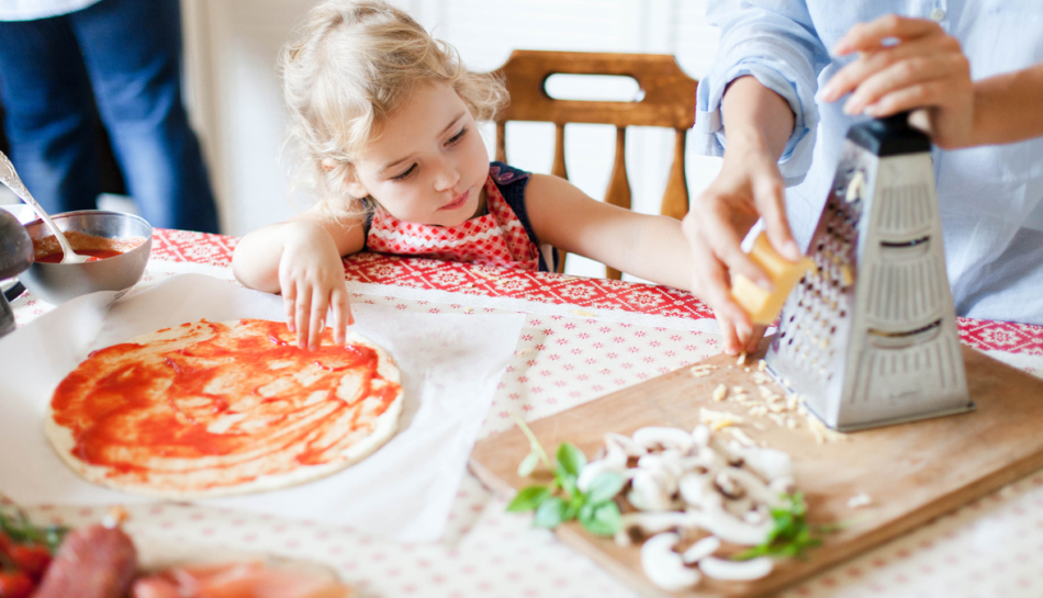 bambina prepara pizza con funghi con mamma