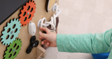 child plays with Montessori panel