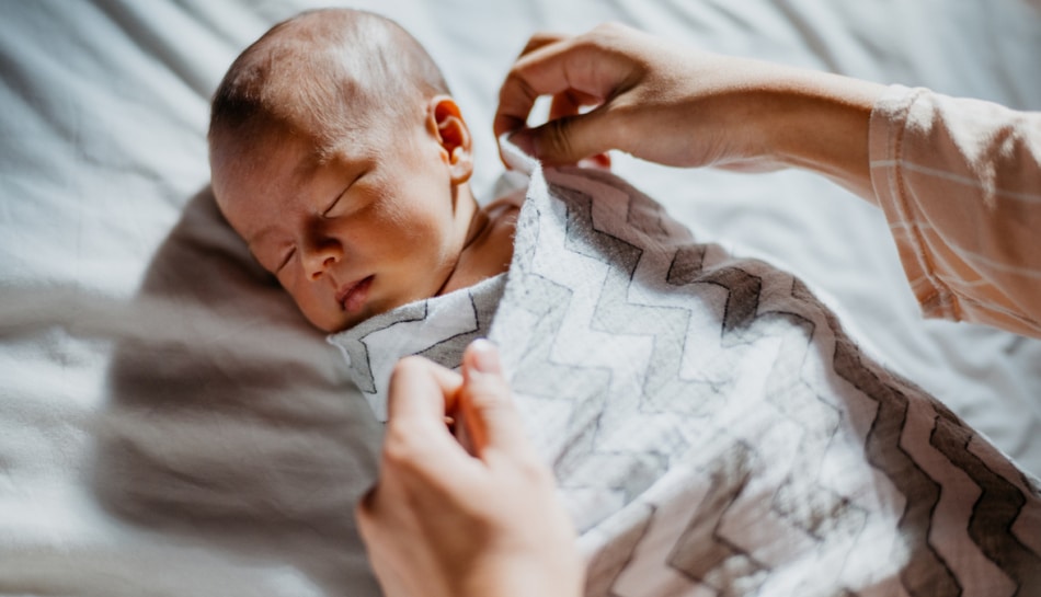 Mamma utilizza la tecnica dello swaddling con il neonato