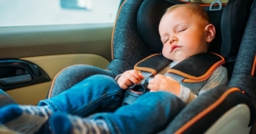 The baby sleeps in a safe car seat