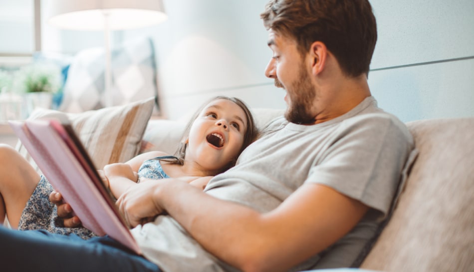 Padre legge un libro per bambini alla figlia