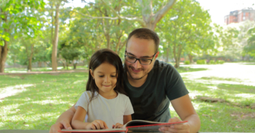 bambina e papà leggono libro sulla natura