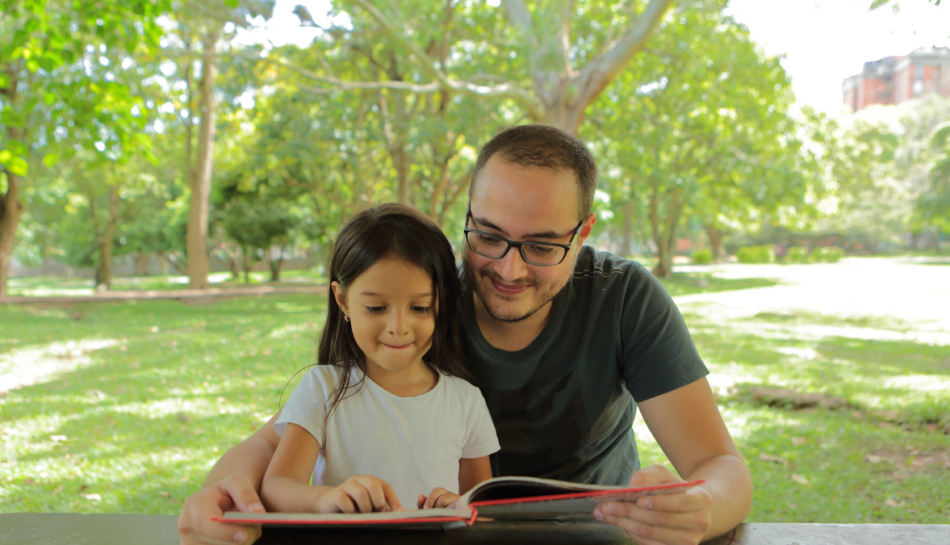 bambina e papà leggono libro sulla natura